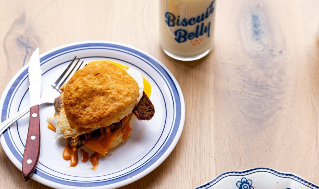 Picture of biscuit breakfast sandwich on a plate with fork and knife
