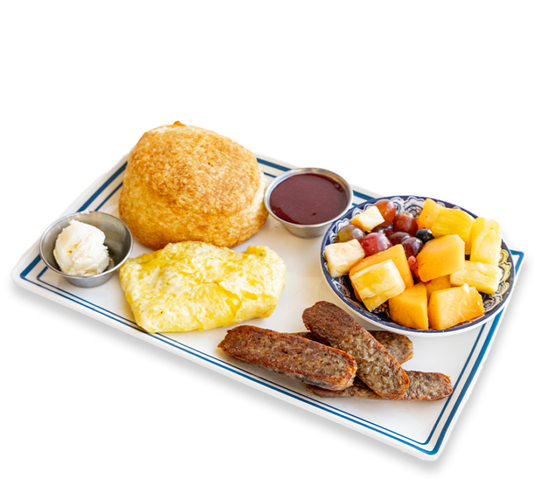 Picture of a biscuit, scrambled eggs, sausage, and assorted fruit on a rectangular plate