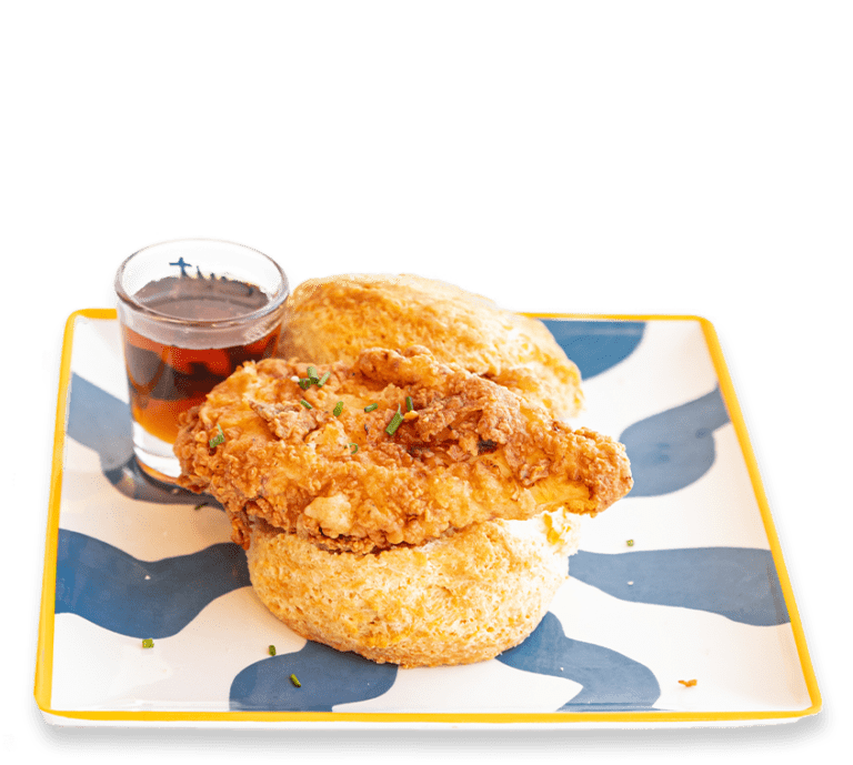 Picture of a basic biscuit sandwich with fried chicken and a side of syrup