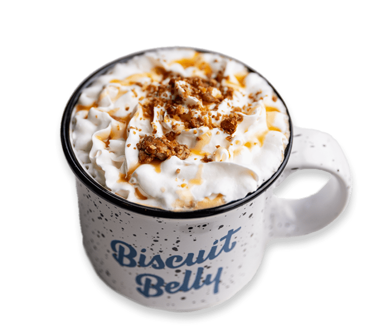 Picture of a latte with whipped cream, caramel sauce, and nut crumbles in a Biscuit Belly branded mug