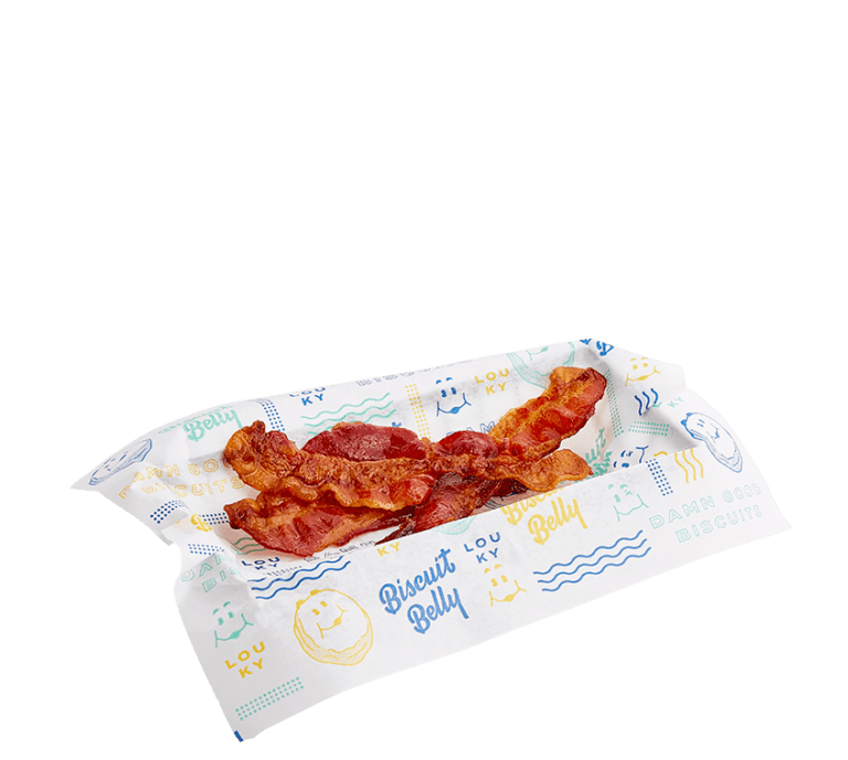 three pieces of bacon in a black wire basket lined with biscuit belly branded paper