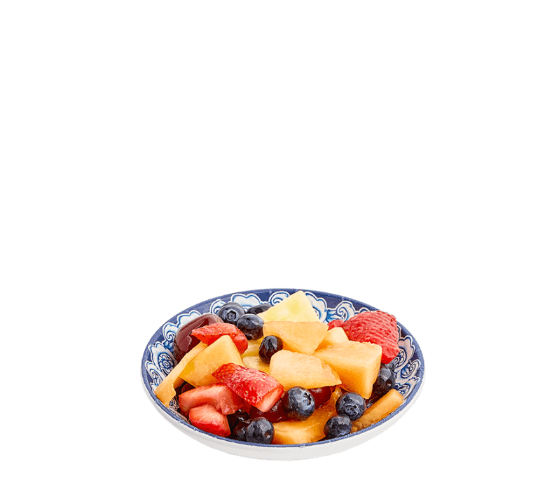 mixed fruit of berries and melon in a blue and white small bowl