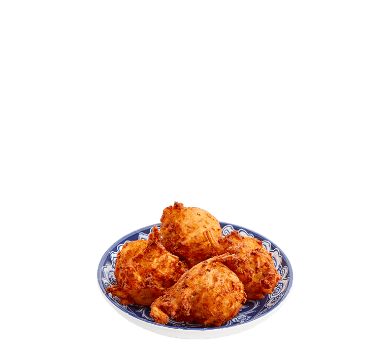 four fried potato balls stuffed with sausage and cheese in a small blue bowl