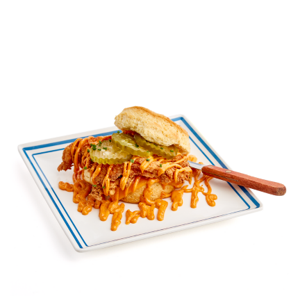 A Fire in Your Belly Biscuit Sandwich on a white plate with a blue border.