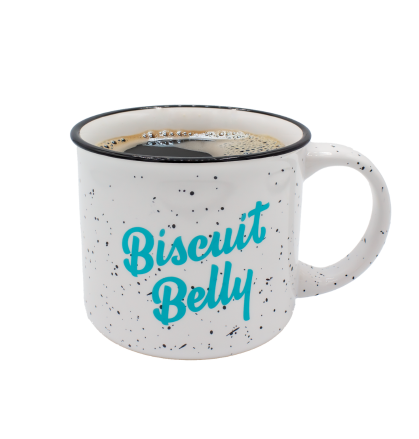 A white speckled mug with the Biscuit Belly logo printed on it in teal lettering.