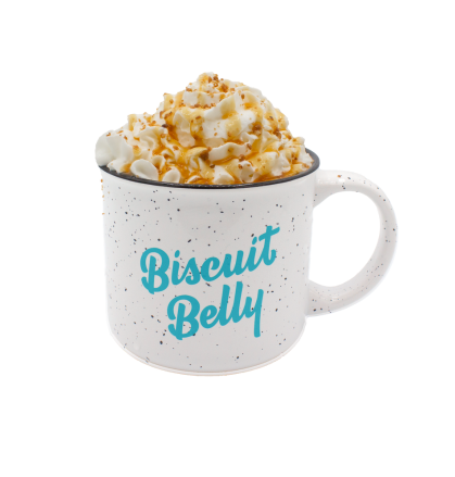 Specialty Coffee in a Biscuit Belly mug topped with whipped cream, a caramel drizzle and crushed pralines.